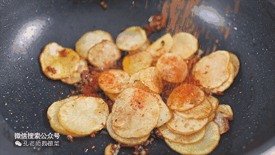下入炸好的土豆片，撒上辣椒面、盐和白芝麻。

